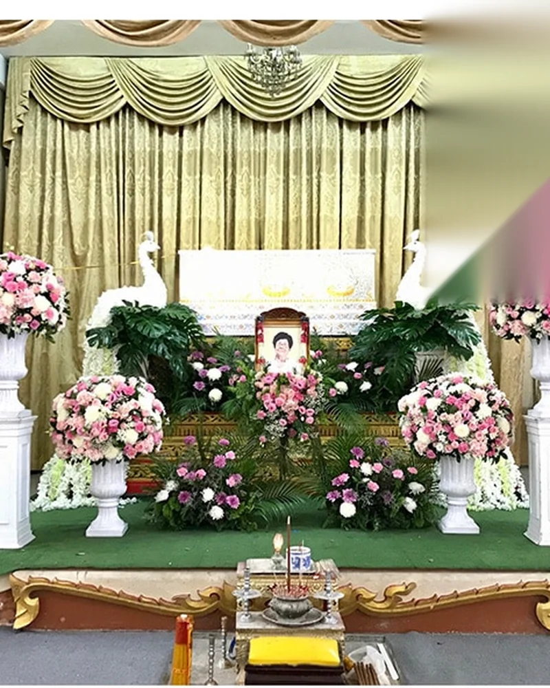 ดอกไม้หน้าหีบและรูปผู้ล่วงลับที่จัดไว้ภายในศาลาวัด