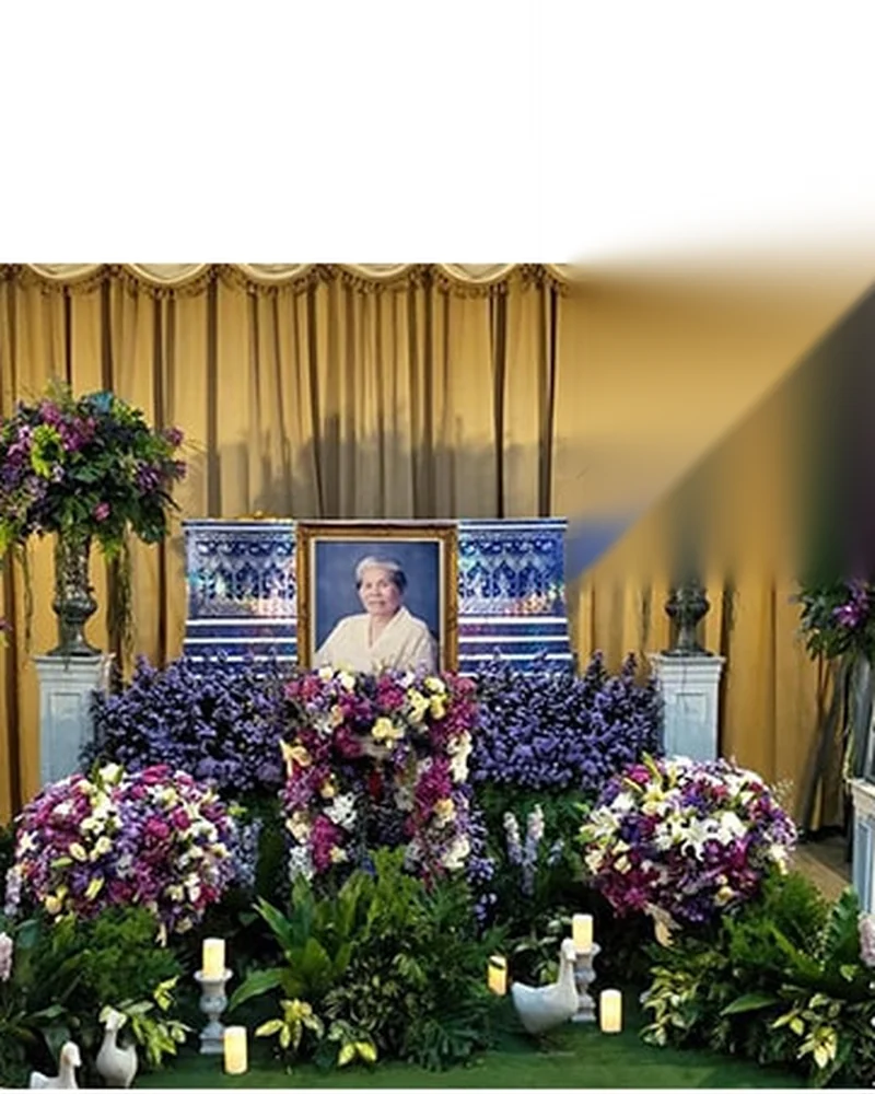 การจัดดอกไม้โทนม่วงขาวหน้าหีบศพในศาลาวัดกรุงเทพฯ