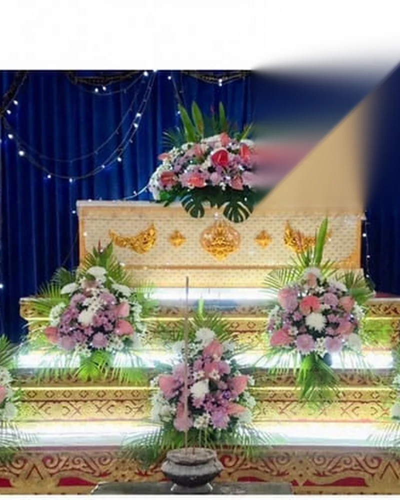 ดอกไม้หน้าศพจัดโทนขาวเรียบร้อยตั้งใกล้หีบศพในศาลาวัด