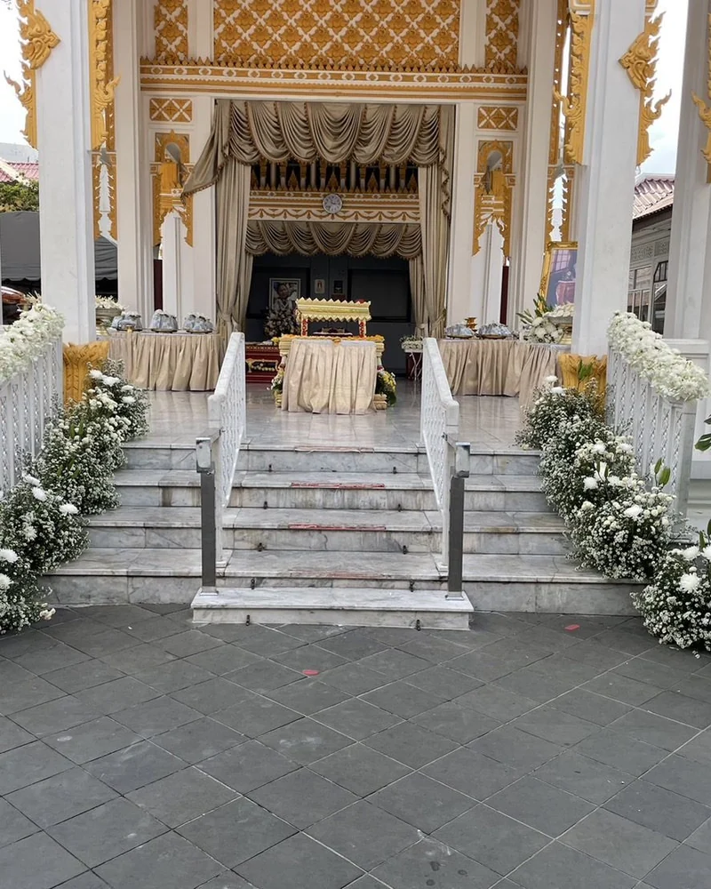บันไดทางขึ้นศาลาบำเพ็ญกุศลประดับดอกไม้สีขาวสองข้างทาง