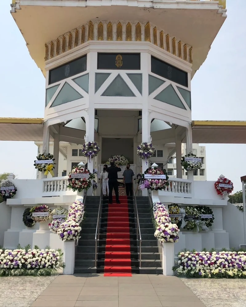 ทางขึ้นศาลาวัดที่ปูพรมและประดับดอกไม้สองข้างทางเดิน